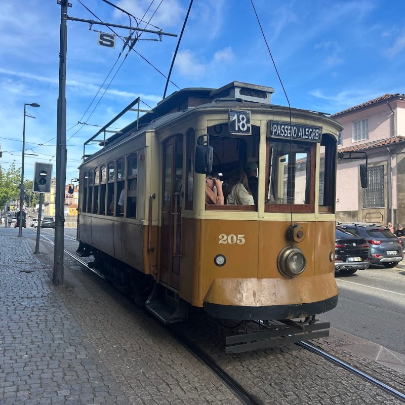 Vintage tram 18 on city street under clear blue sky.