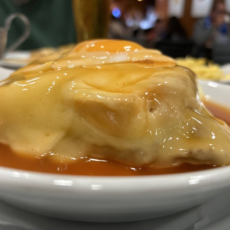 Close-up of a dish with melted cheese and sauce on a plate.
